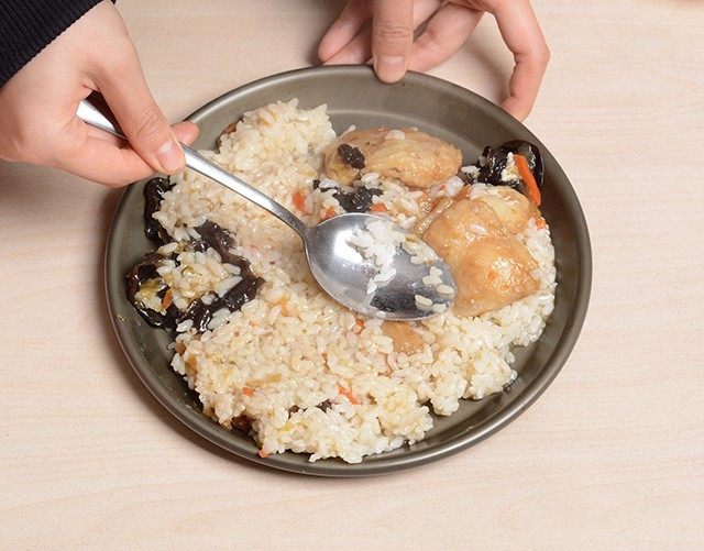 椒香鱼片铁盘焗饭,拌好的米饭倒入烤盘里用勺子铺均匀