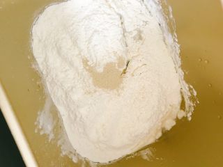枸杞红枣养生软欧包（不含一滴油）,将除了果干（枸杞、红枣干）和熟芝麻之外的材料依次加入面包机内，先是冰牛奶，接着一角盐，一角红糖，接着是高筋面粉，最后是中间戳个小洞撒入干酵母。启动和面程序，时间为20分钟左右。