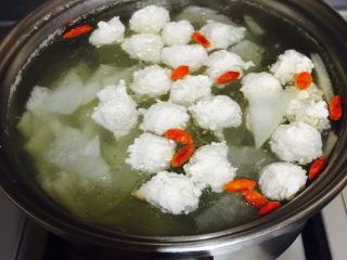 冬瓜丸子汤,一个个丸子下入锅中，稍煮即可，然后关火调入适量盐，放几颗枸杞点缀。