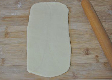 牛肉松面包,取一个小面团，擀成长方形薄片。