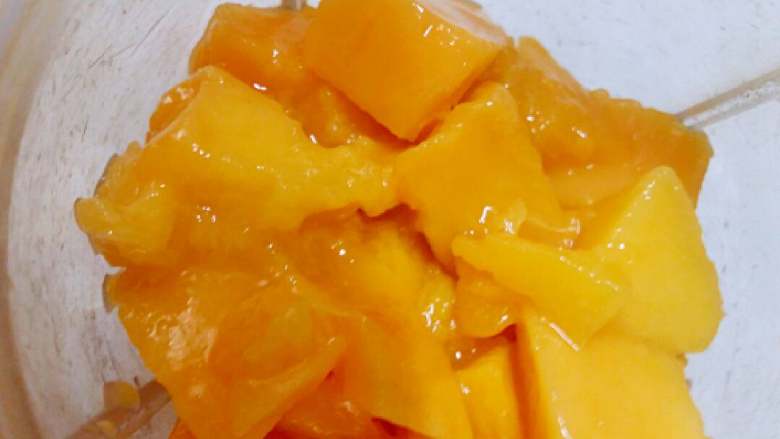 芒果胡萝卜汁+#夏天的味道#,胡萝卜芒果各一半放入榨汁机，加入适量的凉开水榨汁倒出，再榨另一半。