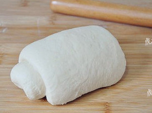 免揉面的肉松面包卷,发酵完成的面团取出，擀开卷起两到三次，排去大气泡，然后再卷成团醒面10分钟。