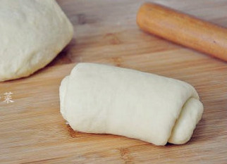 酷暑中清新怡人的椰香面包,然后将面团按照模具的大小分成两个小面剂子，并逐个擀开卷起成小面卷，在醒面5分钟。