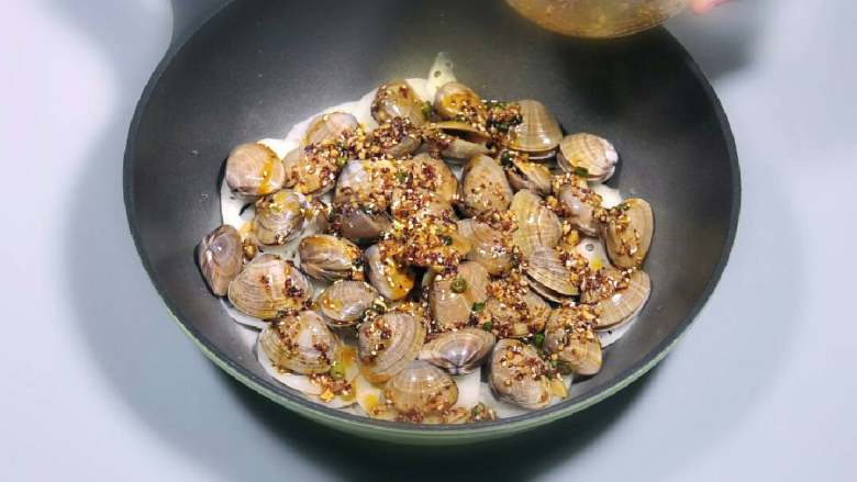 红油蚬子,在藕上面铺好黄蚬子，尽量铺平，这样可以均匀受热入味，再把调好的红油料汁全部撒入。