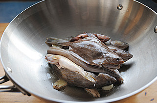 家常味最好味【家常烧杂鱼】,将鱼铺在锅内，单面略煎半分钟；