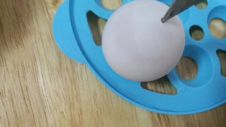 彩色糯米蛋,先取1只蛋利用剪刀尖部从蛋尖这头顶中间敲一个小洞如图，