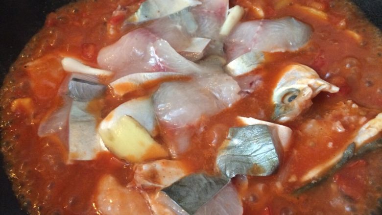 番茄䲝鱼#挑战鸡蛋的100种做法#,煮开以后，迅速把鱼头骨先放进锅，再放鱼肉，加入适量的盐
