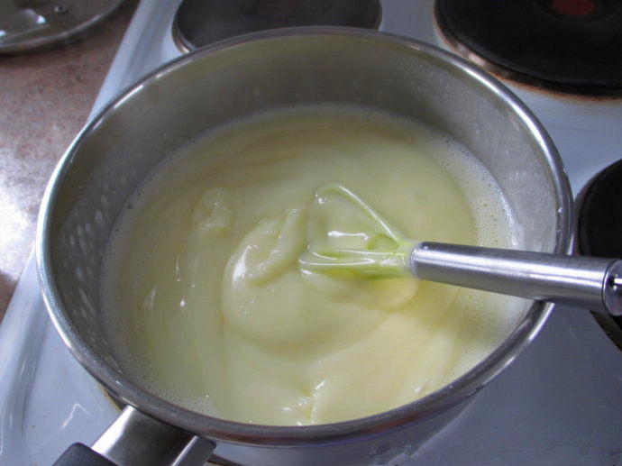 香草卡仕达方块——Vanilla Custard Squares ,往牛奶里加入卡仕达混合物，用打蛋器快速搅拌，直至卡仕达变浓稠，离火，加入香草精，搅拌均匀