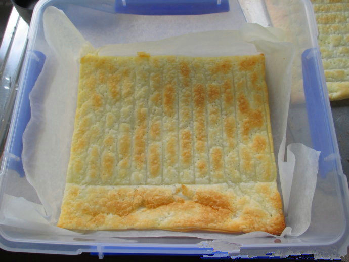香草卡仕达方块——Vanilla Custard Squares ,准备一个大小合适的容器，铺上油纸，放入一张烤好的酥皮