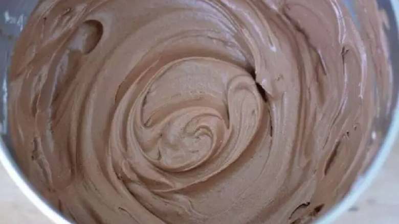 巧克力奶油雪糕蛋糕,
将巧克力放微波炉加热，融化后放一旁冷却打发软化的奶油奶酪。加入糖和冷却后的巧克力，拌匀。打发至顺滑，如下图所示
