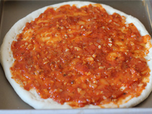 打造paty上超实惠的大披萨——金枪鱼披萨 ,醒发好的披萨面皮抹上一层披萨酱。