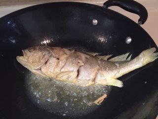 红烧黄花鱼,煎到图上熟度，翻一面继续煎。两面煎好后，加入蒜片，姜丝。