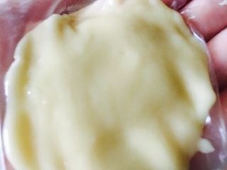 广式豆沙蛋黄月饼,先将面团分均匀等份，取一饼皮面团放左手手掌上，用右手大拇指根部按压成四周薄、中间厚的圆饼皮。