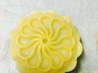 广式豆沙蛋黄月饼,轻轻在月饼表面刷一层蛋黄液，不要刷太多，以免烤出的花纹不清晰