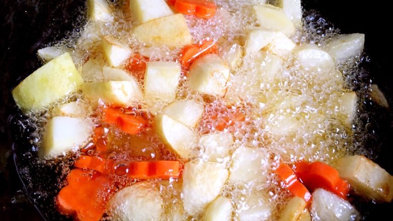 咖喱土豆鸡块盖浇饭,另起一锅，放油烧热下土豆块和胡萝卜煎至金黄色捞出。