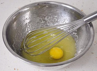 助兴小点心：核桃饼干,盆中倒入葵花籽油和绵白糖搅打均匀，再磕入一个鸡蛋搅打至浓稠状。