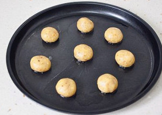 助兴小点心：核桃饼干,将大面团分割称量出15克/个的小剂子，滚成小圆球摆放在烤盘上。