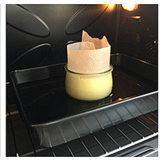十五分钟快手“乳酪蛋糕”,将玻璃罐置于加入水的深盘中，置预热好的烤箱下层烘烤，烘烤完成后关闭电源留在炉中待完全凉透取出