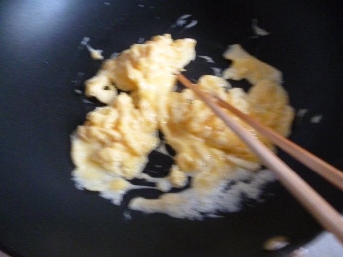 鲑鱼炒饭～～剩米饭的美丽转身,起锅热油后入打散的鸡蛋，中火至略凝固状态后迅速用筷子划散，至微嫩的状态出锅。