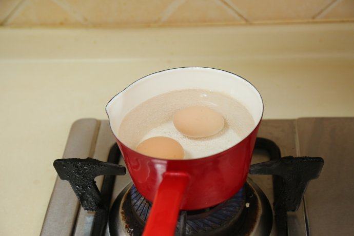 教你如何在家做一碗高颜值的［海鲜乌冬面］,鸡蛋中火煮五分钟，关火，放入冷水中浸泡。
