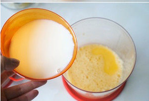 上班族下午茶必备—鸡蛋布丁,将处理好的牛奶加入打好的蛋液中搅拌均匀。