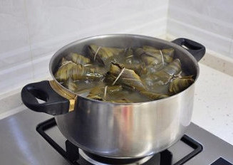 四角粽子的包法：红豆蜜枣粽子,小火煮4-5个小时，中途要补开水一次，煮至香味浓郁，苇叶变色，汤汁也变得浓稠了即可。