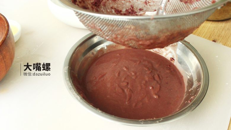 Q萌红糖冰皮月丨大嘴螺,将软烂的红豆用勺子压碎，加入适量水，用滤网将纯正的红豆原汁过滤到碗中，这样还能将多余的红豆皮一同过滤出去，最后制成的红豆沙的口感就会更加的柔
