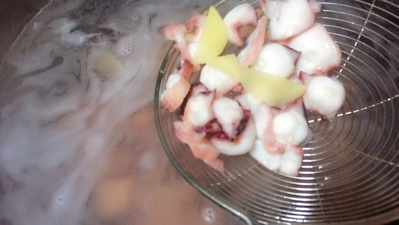 蒜苗爆炒章鱼足,起锅烧水，放入几片生姜，将腌制好的章鱼足倒入煮沸的水中焯水，半分钟后捞出滤水。