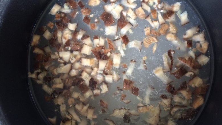 香菇滑肉粥,待锅中大米煮沸，放入香菇跟姜末一起煮至粥软糯黏稠