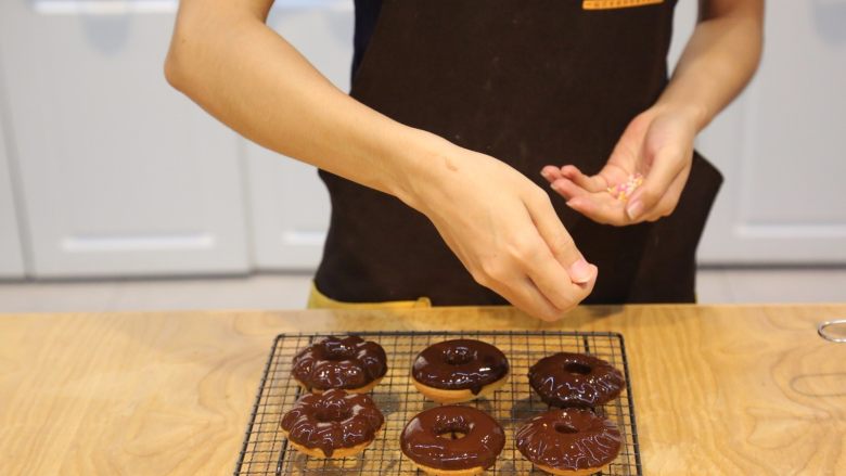烤箱版#巧克力甜甜圈,在巧克力酱还没凝固时，撒上装饰糖果或果仁。