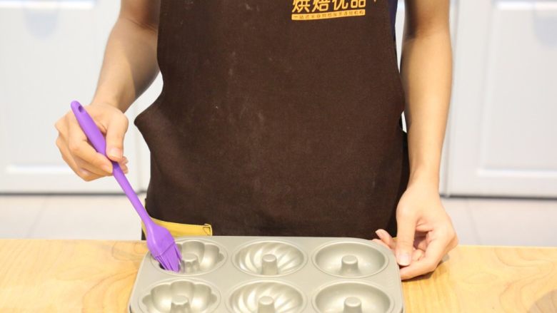 烤箱版#巧克力甜甜圈,在模具中刷一层黄油，方便脱模