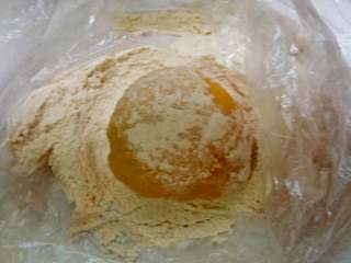 南瓜冰皮水果月饼+#中秋食饼记#,把做好的冰包放熟面粉中来回滚一下，