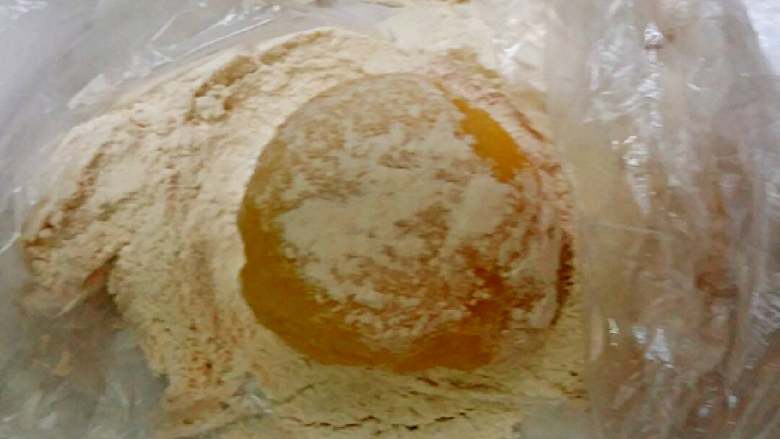 南瓜冰皮水果月饼+#中秋食饼记#,把做好的冰包放熟面粉中来回滚一下，