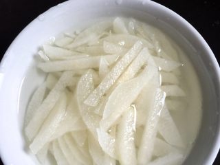 韩式冷面,第4步：梨子只需要半个就够了，切好的丝放到糖水里，防止氧化变色。
