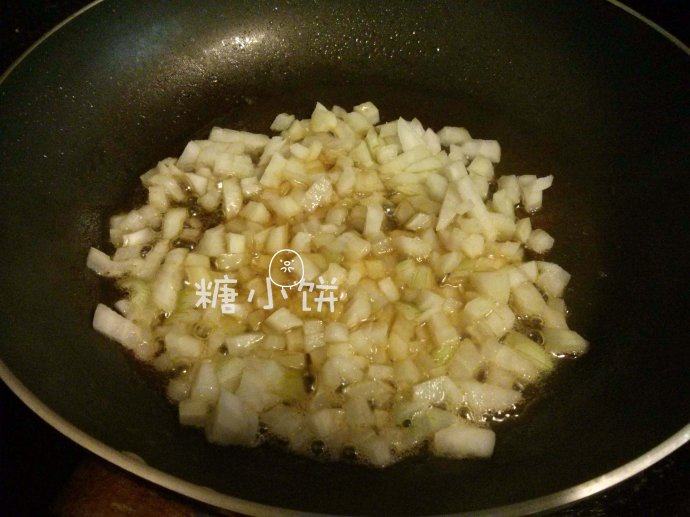 西式苹果炖饭,洋葱去皮切丁。锅内加黄油烧热，加入洋葱丁翻炒