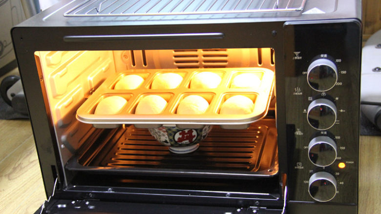 蔓越梅乳酪小餐包,烤箱提前预热180度15分钟，预热完成，将烤网放在烤箱中下层，模具放在烤网上。上下火180度烤20分钟。