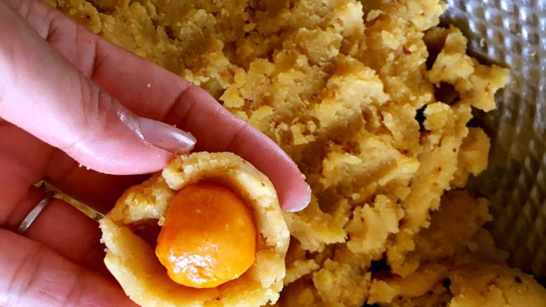 广式绿豆沙蛋黄月饼＋#中秋食饼记#,把绿豆糕捏成碗状，包入蛋黄。