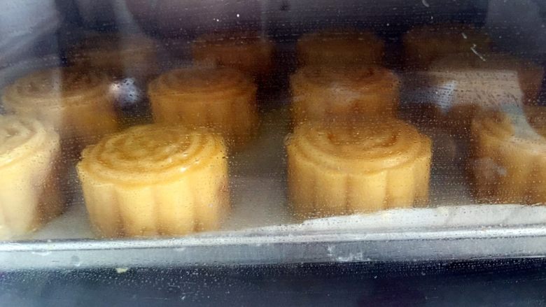 广式绿豆沙蛋黄月饼＋#中秋食饼记#,上下火180度烤30分钟左右，最后几分钟要多观察，月饼表面上色呈金黄色即可，因为每个烤箱的温度有个体差异。