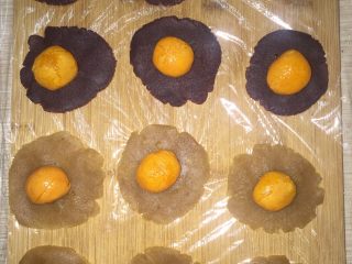 莲蓉蛋黄月饼(Moon Cake)#中秋食饼记#,然后把莲蓉和豆沙馅压成片状，上面放鸭蛋黄。