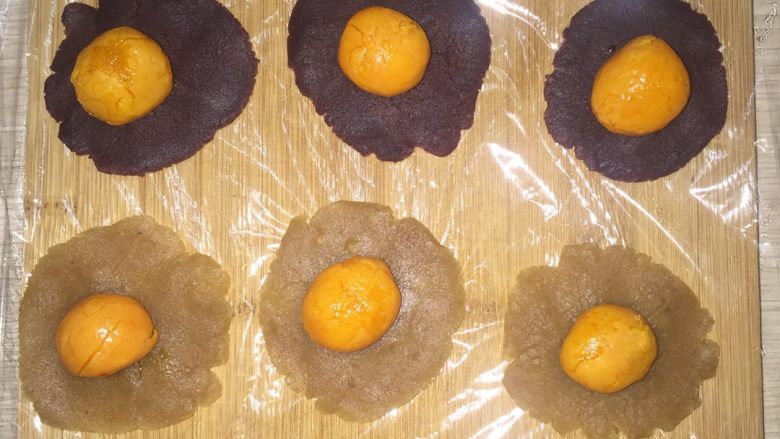 莲蓉蛋黄月饼(Moon Cake)#中秋食饼记#,然后把莲蓉和豆沙馅压成片状，上面放鸭蛋黄。