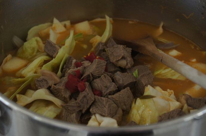 寒天一锅暖，新版罗宋汤,加入土豆，卷心菜和辣椒，烧开，盖上锅盖转小火将土豆和胡萝卜煮熟。（大约25分钟）