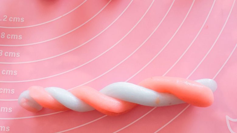 彩色冰皮月饼#中秋食饼记#,各取一个小面团分别搓成长条形，缠绕一块，两头捏紧。