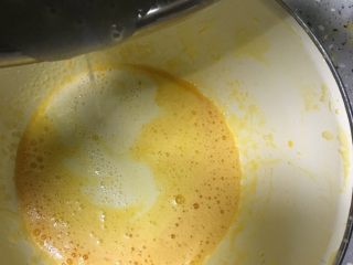 沙拉肉松卷,将搅好的橄榄油牛奶倒入打散的蛋黄中，用手动打蛋器搅匀