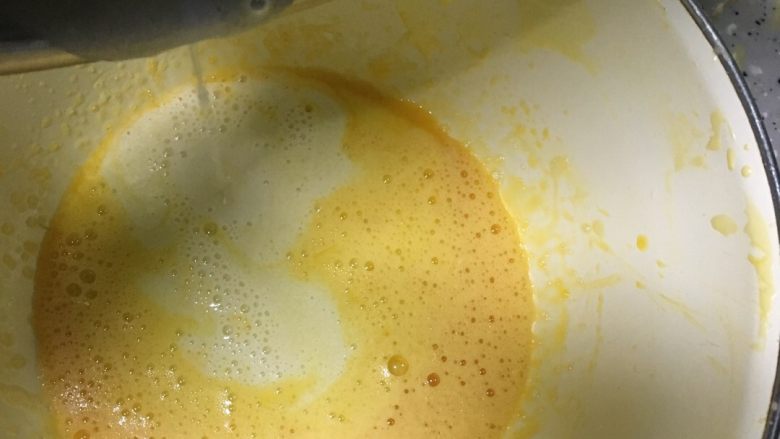 沙拉肉松卷,将搅好的橄榄油牛奶倒入打散的蛋黄中，用手动打蛋器搅匀
