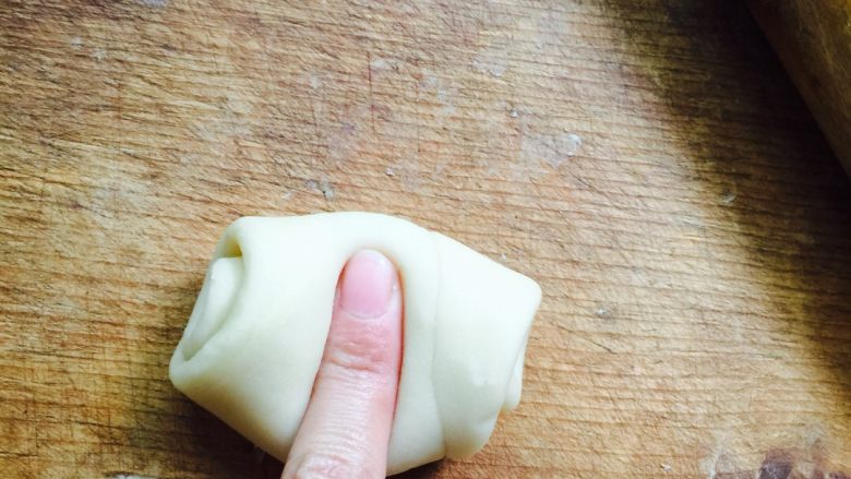 蛋黄莲蓉月饼,取一个松弛好的面卷，食指按压中间