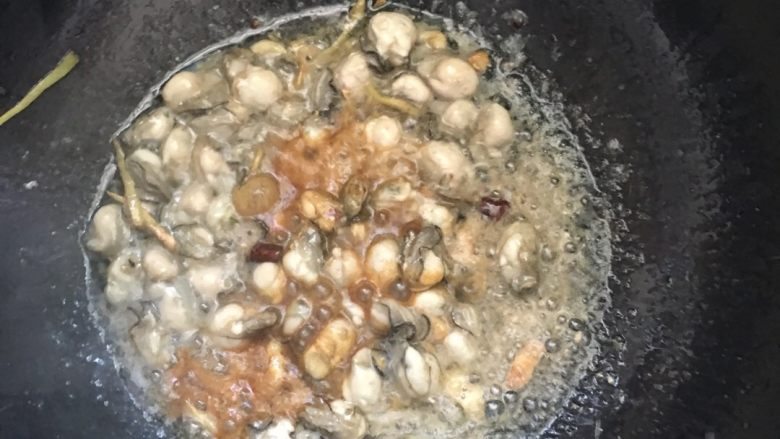 #年夜饭#海蛎紫菜煲,待海蛎表面的淀粉凝固后，翻炒几下，加入一勺酱油和料酒翻炒。