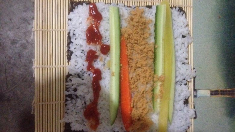 肉松寿司,将帘子平铺，拿一张海苔放在帘子上，放米饭、调味萝卜、胡萝卜、黄瓜、<a style='color:red;display:inline-block;' href='/shicai/ 432'>肉松</a>！根据自己的口味放入酱（番茄酱、沙拉酱、鱼子酱……）