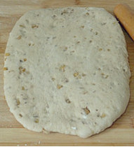 将面粉烤香了再做面包-熟粉核桃面包 ,将发酵好的面团取出，擀去气泡后醒面10分钟。