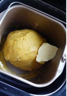 多汁熟粉南瓜面包 ,开启揉面程序，揉成光滑面团后加入黄油继续揉面。