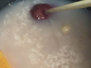 红薯莲子粥,这个时候可以放几个大红枣进去，用筷子压进粥里重新盖上盖子闷着，你就可以洗洗刷刷去了。